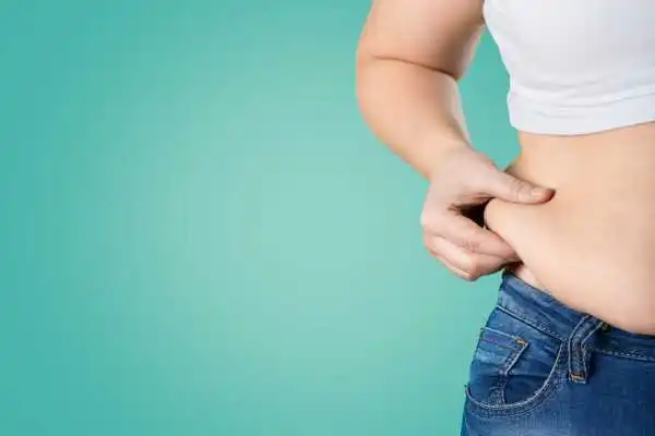 Image of woman pinching her love handles to show weight gain Shefford